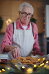 Ein älterer Mann backt zu Hause Weihnachtslebkuchen. - HPIF10459