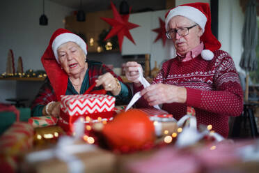 Ein älteres Ehepaar feiert Weihnachten und beschenkt sich gegenseitig. - HPIF10476