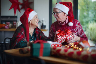 Ein älteres Ehepaar feiert Weihnachten und beschenkt sich gegenseitig. - HPIF10478