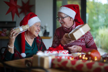 Ein älteres Ehepaar feiert Weihnachten und beschenkt sich gegenseitig. - HPIF10479