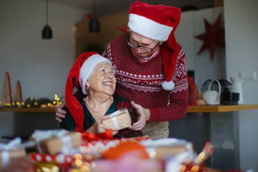 Ein älteres Ehepaar feiert Weihnachten und beschenkt sich gegenseitig. - HPIF10481