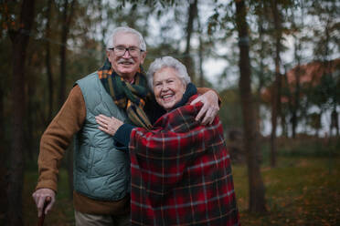 Porträt eines älteren Paares, das zusammen in der herbstlichen Natur spazieren geht. - HPIF10528