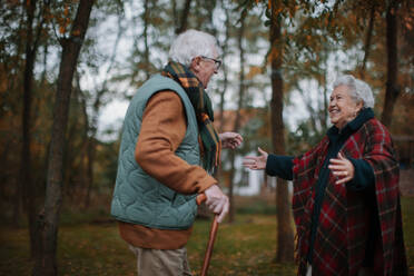 Senior couple greeting together in autumn nature. - HPIF10531
