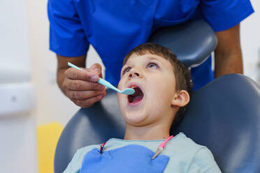 Porträt eines kleinen Jungen bei einer zahnärztlichen Untersuchung. - HPIF10564