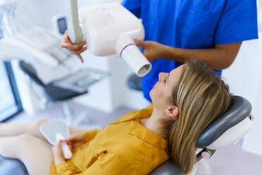 Junge Frau beim Zahnarzt, der eine Röntgenaufnahme der Zähne macht. - HPIF10588