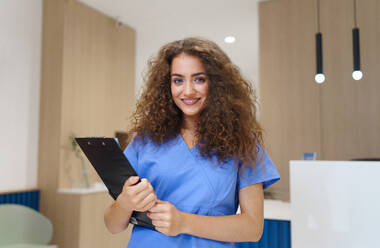 Portrait of dentist nurse posing at reception on a private dental clinic. - HPIF10614