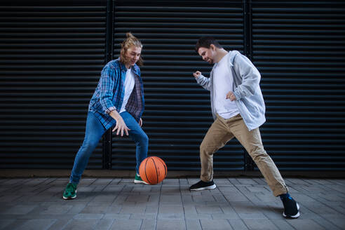Ein Mann mit Down-Syndrom spielt mit seinem Freund Basketball im Freien. Konzept der Freundschaft und Integration von Menschen mit Behinderung in die Gesellschaft. - HPIF10616