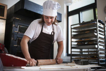 Junger Bäcker bei der Zubereitung von Gebäck in einer Bäckerei. - HPIF10649