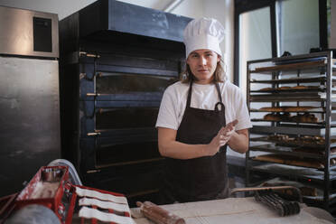 Junger Bäcker bei der Zubereitung von Gebäck in einer Bäckerei. - HPIF10650