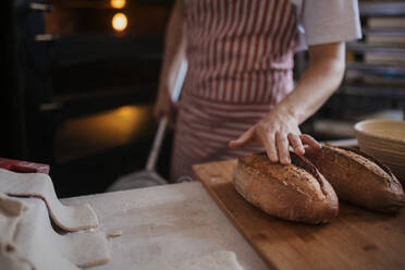 Nahaufnahme eines Bäckers mit frischem, gerade gebackenem Brot. - HPIF10658