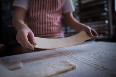 Nahaufnahme eines Bäckers bei der Zubereitung von Gebäck in einer Bäckerei. - HPIF10661