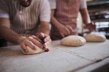 Nahaufnahme von Bäckern bei der Zubereitung von frischem Gebäck in einer Bäckerei. - HPIF10672