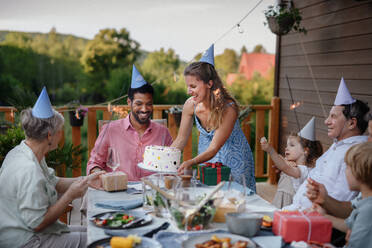 Eine Mehr-Generationen-Familie feiert Geburtstag und feiert eine Gartenparty im Hinterhof auf der Veranda. - HPIF10743