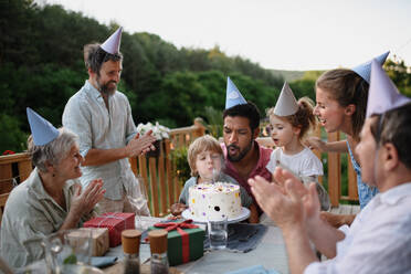 Eine Mehr-Generationen-Familie feiert Geburtstag und feiert eine Gartenparty im Hinterhof auf der Veranda. - HPIF10744