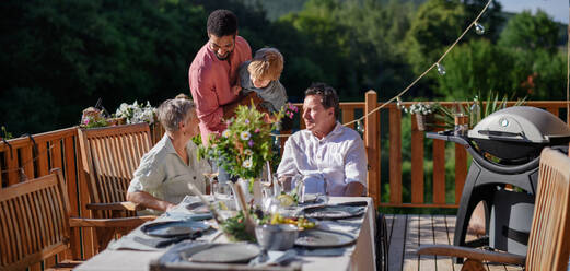 Multi generation family party outside in the backyard on a patio. - HPIF10753