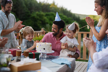 Eine Mehr-Generationen-Familie feiert Geburtstag und feiert eine Gartenparty im Hinterhof auf der Veranda. - HPIF10776