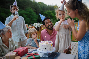 Eine Mehr-Generationen-Familie feiert Geburtstag und feiert eine Gartenparty im Hinterhof auf der Veranda. - HPIF10777