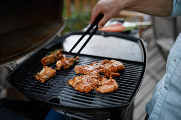 Ein nicht erkennbarer Mann grillt Fleisch, Rippchen und Wings, auf dem Grill während einer Familien-Sommer-Gartenparty, Nahaufnahme - HPIF10786