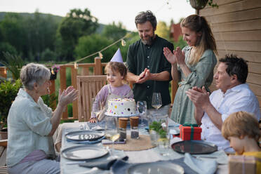 Eine Mehr-Generationen-Familie feiert Geburtstag und feiert eine Gartenparty im Hinterhof auf der Veranda. - HPIF10790