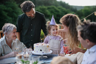 A multi generation family celebratiing birthday and have garden party outside in the backyard on patio. - HPIF10794