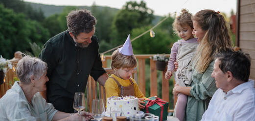 Eine Mehr-Generationen-Familie feiert Geburtstag und feiert eine Gartenparty im Hinterhof auf der Veranda. - HPIF10798