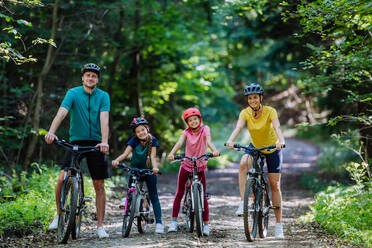 Young family with little children at a bike trip together in nature. - HPIF10811
