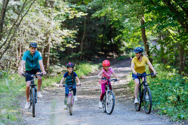 Young family with little children at a bike trip together in nature. - HPIF10813