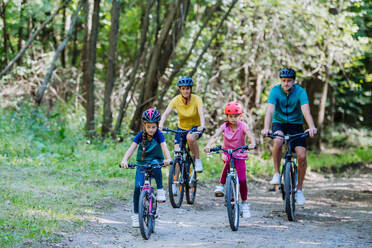 Young family with little children at a bike trip together in nature. - HPIF10814