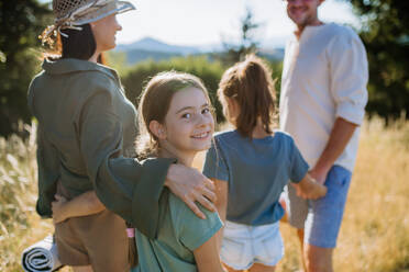 A happy young parents with daughters walking for picnic in nature in summer day. - HPIF10835