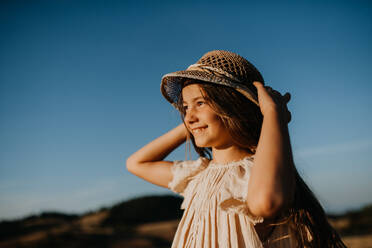 A portrait of a beautiful little girl in summer in nature during sunset.  stock photo