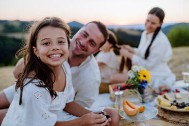 Eine glückliche Familie mit Kindern beim Picknick im Park, Eltern mit Kindern beim gesunden Essen im Freien. - HPIF10874