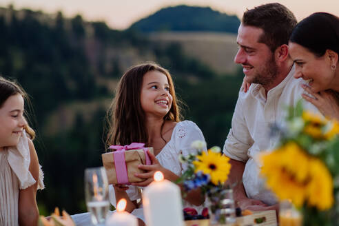 Eine glückliche Familie mit Kindern feiert Geburtstag mit Geschenken im Freien bei einem Picknick im Park. - HPIF10881