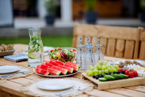 Ein gedeckter Esstisch für ein Abendessen auf der Terrasse im Sommer, Konzept der Gartenparty. - HPIF10882