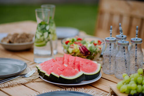 Ein gedeckter Esstisch für ein Abendessen auf der Terrasse im Sommer, Konzept der Gartenparty. - HPIF10885
