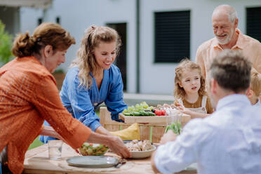 Eine Mehrgenerationenfamilie feiert eine Gartenparty im Freien. - HPIF10889