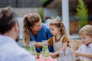 Eine Mehrgenerationenfamilie feiert eine Gartenparty im Freien. - HPIF10891