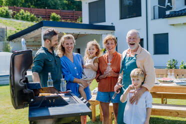 Eine Mehrgenerationenfamilie, die im Sommer während einer Gartenparty im Hinterhof grillt - HPIF10904