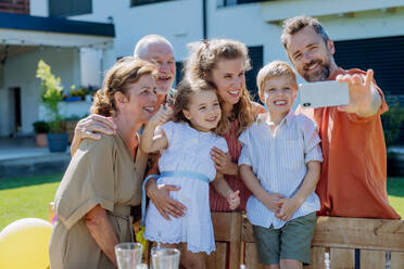 A multi generation family taking selfie on backyard in summer during garden party - HPIF10920