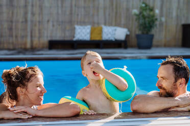 Glückliche junge Familie, die den Sommer gemeinsam im Schwimmbad verbringt. - HPIF10957