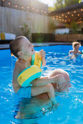 Ein Großvater mit seinem granson Spaß haben zusammen beim Spielen im Schwimmbad im Garten. - HPIF10959