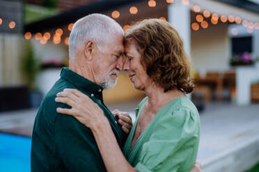 Eine ältere Frau und ein Mann tanzen zusammen in einem Garten im Sommer - HPIF10965