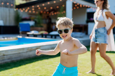 Kleiner Junge genießt die Sommerzeit mit seiner Mutter in ihrem Garten mit Swimmingpool. - HPIF11055