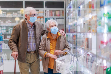 Älteres Ehepaar auf der Suche nach Medikamenten in einem Apothekenladen. - HPIF11069