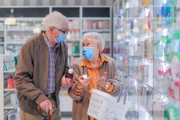 Älteres Ehepaar auf der Suche nach Medikamenten in einem Apothekenladen. - HPIF11070