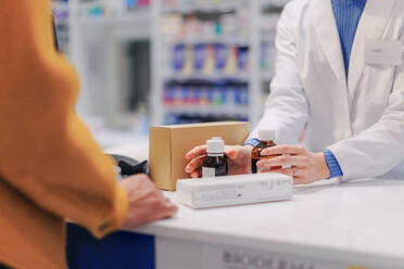 Close up of a pharmacist selling medications to the customer. - HPIF11090