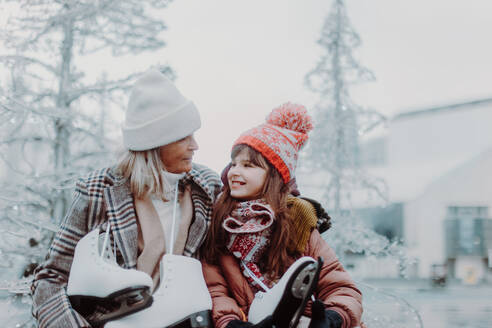 Portrait of grandmother and granddaughter in winter at an outdoor ice skating rink. - HPIF11168