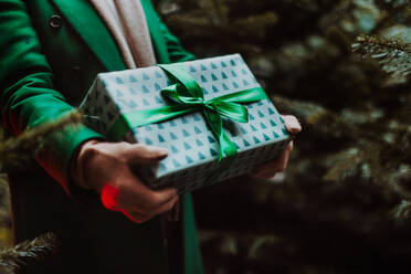 Nahaufnahme einer Frau mit Geschenken, draußen auf dem Weihnachtsmarkt. - HPIF11172