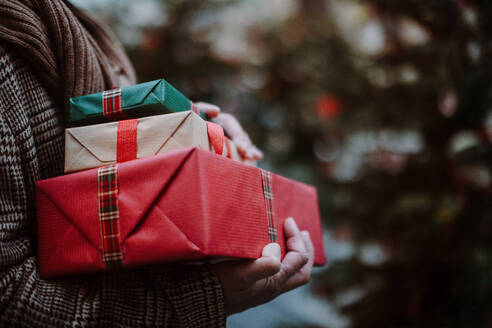 Nahaufnahme eines Mannes mit Geschenken, draußen auf dem Weihnachtsmarkt. - HPIF11174