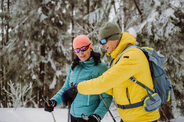 Ein älteres Ehepaar überprüft eine Smartwatch beim Skifahren. - HPIF11279