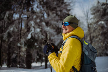Älterer Mann bewundert die Natur beim Skilanglauf im Wald. - HPIF11284
